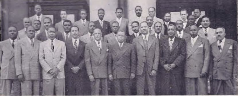 Wide group photograph of the Chicago delegation in suits arranged in rows on outdoor steps, Dr. Simmons C. Hamilton at front center